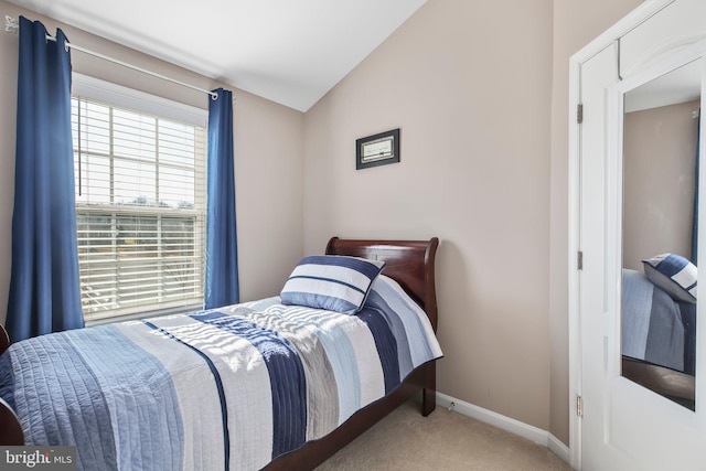 carpeted bedroom featuring baseboards and vaulted ceiling