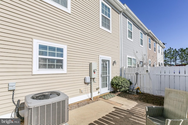 rear view of property featuring a patio area, central air condition unit, and fence