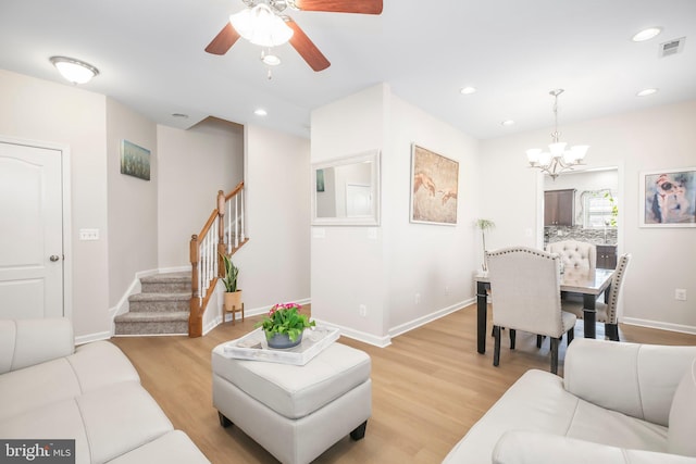 living room featuring visible vents, baseboards, stairs, recessed lighting, and light wood-style flooring