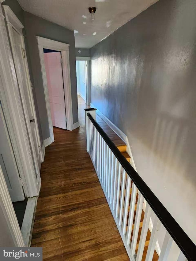 hall featuring baseboards and wood finished floors