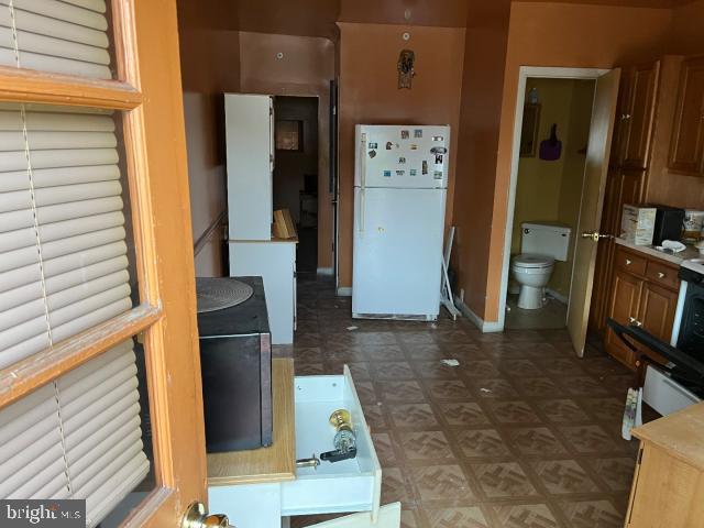 kitchen with freestanding refrigerator and baseboards