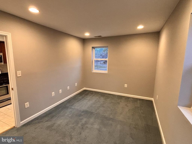 unfurnished room with dark colored carpet, recessed lighting, visible vents, and baseboards