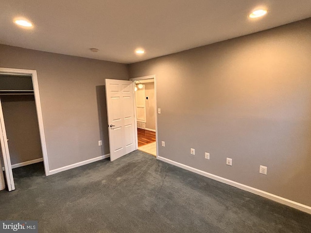 unfurnished bedroom featuring baseboards, dark colored carpet, a closet, and recessed lighting