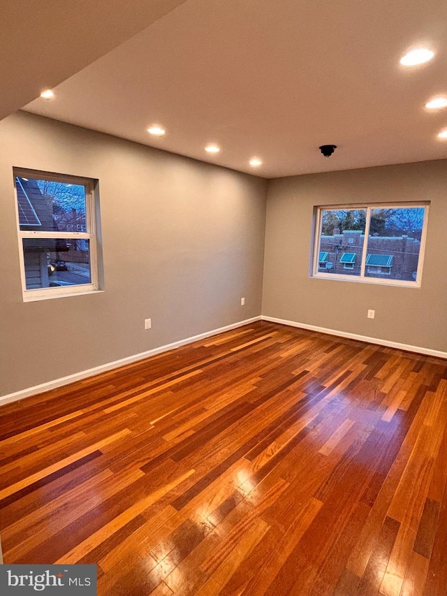 unfurnished room with hardwood / wood-style flooring, baseboards, and recessed lighting