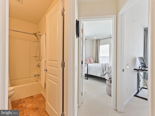 ensuite bathroom featuring shower / bathtub combination, ensuite bath, and baseboards