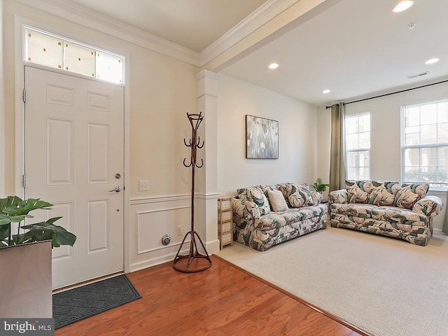 entryway featuring visible vents, a wainscoted wall, ornamental molding, wood finished floors, and recessed lighting