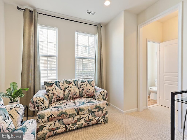 living area featuring carpet, visible vents, and baseboards