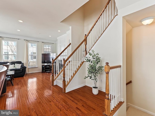 stairway featuring hardwood / wood-style flooring, baseboards, and recessed lighting