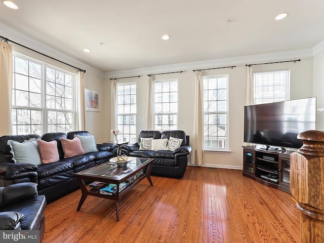 living room with recessed lighting, plenty of natural light, wood finished floors, and crown molding