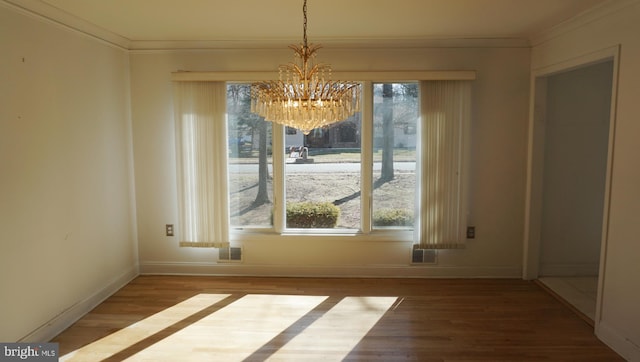 unfurnished dining area featuring ornamental molding, visible vents, and wood finished floors