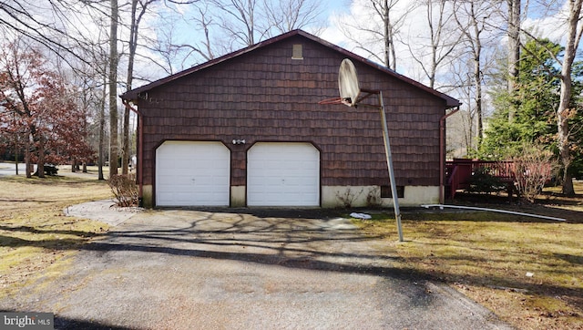 view of side of property featuring a detached garage and an outbuilding