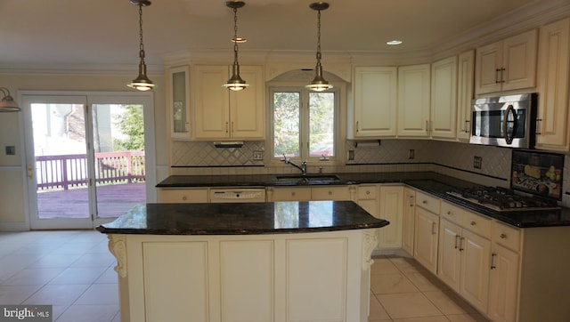 kitchen with a sink, gas stovetop, ornamental molding, tasteful backsplash, and stainless steel microwave