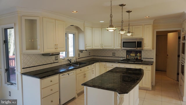 kitchen with backsplash, pendant lighting, stainless steel appliances, and a sink