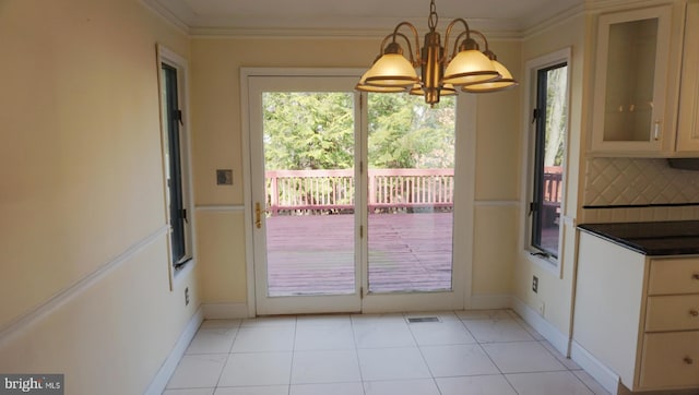 entryway featuring ornamental molding, a chandelier, visible vents, and baseboards