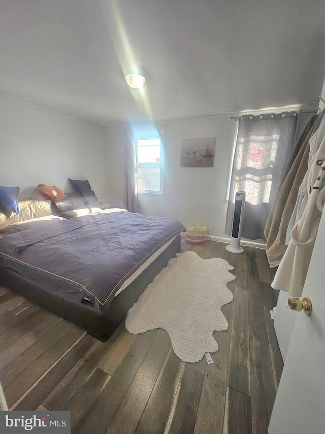 bedroom with dark wood-style flooring