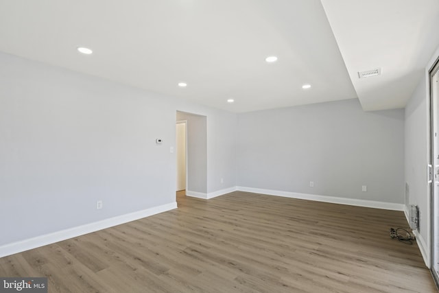 unfurnished room with recessed lighting, visible vents, baseboards, and wood finished floors