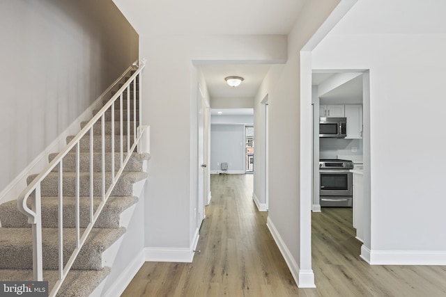 stairs with baseboards and wood finished floors