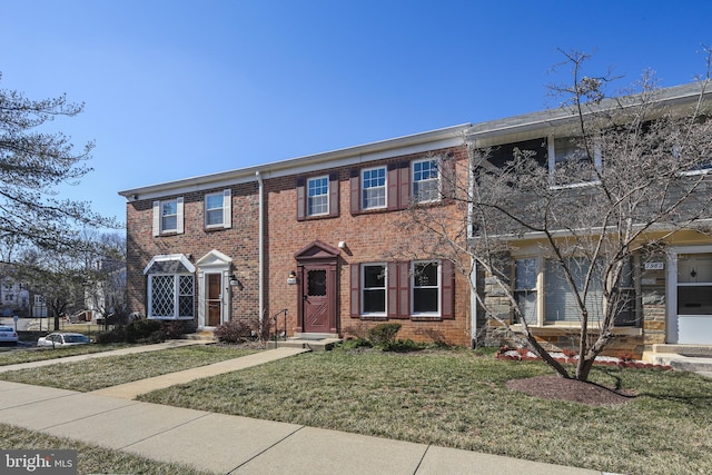 view of front of property with brick siding and a front lawn