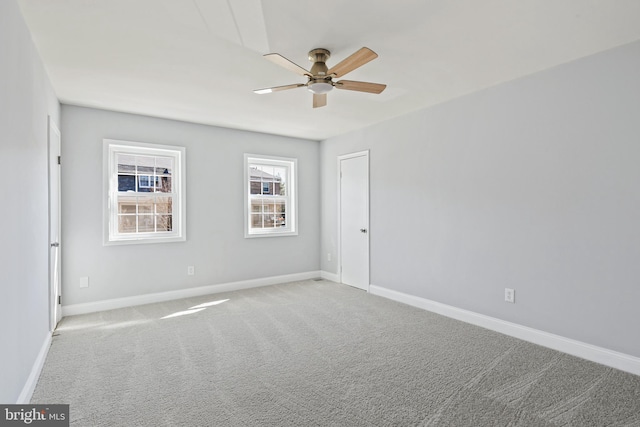 empty room with carpet floors, baseboards, and a ceiling fan