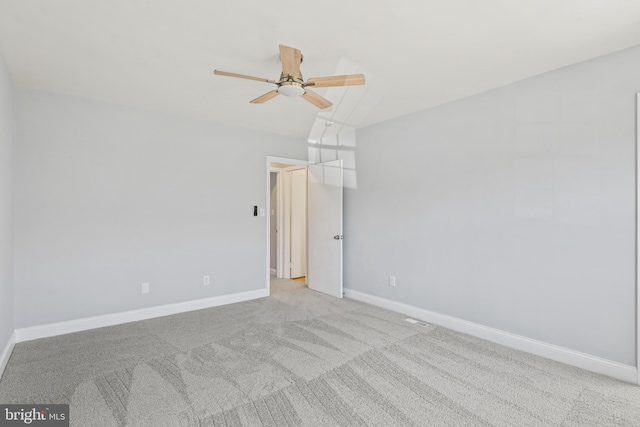 spare room with light carpet, a ceiling fan, and baseboards