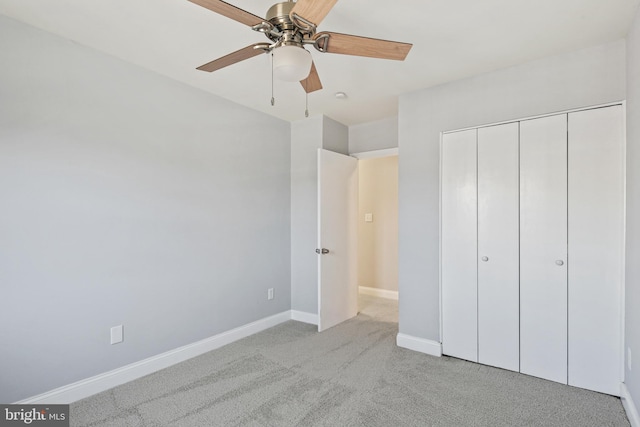 unfurnished bedroom with light carpet, a ceiling fan, baseboards, and a closet