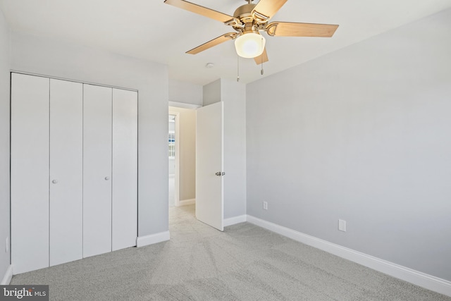 unfurnished bedroom with a ceiling fan, a closet, light colored carpet, and baseboards