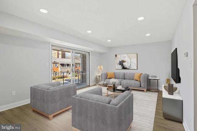 living area with baseboards, light wood finished floors, visible vents, and recessed lighting