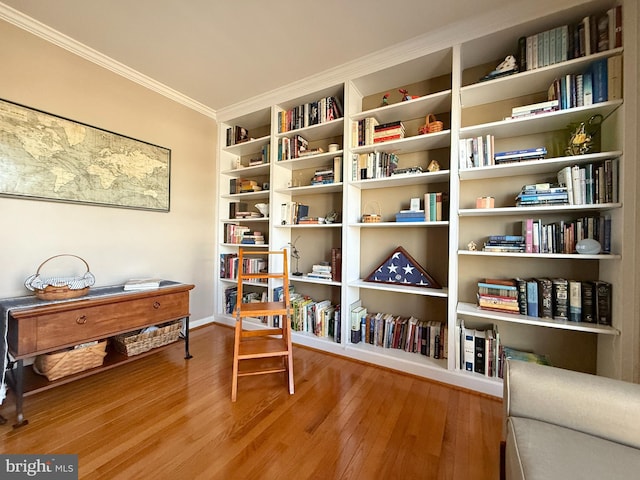 sitting room with wood finished floors and ornamental molding