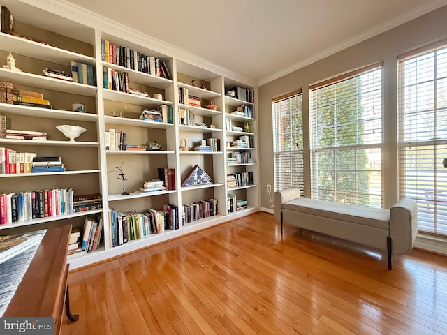 sitting room featuring wood-type flooring and ornamental molding