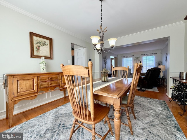 dining room featuring a notable chandelier, wood finished floors, and crown molding