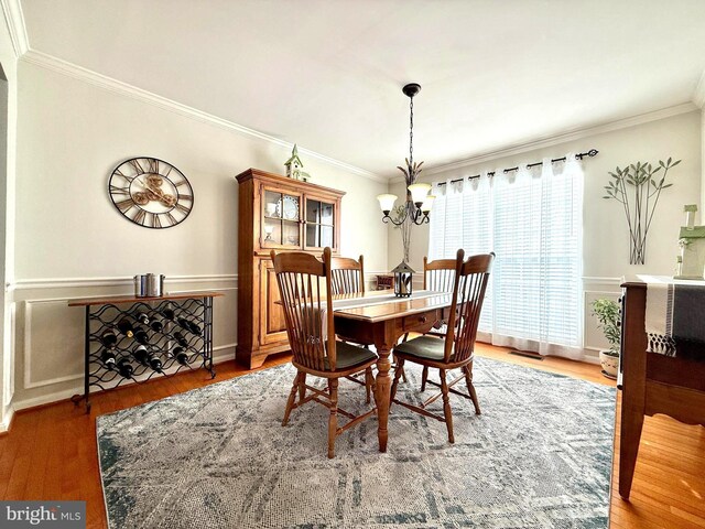 dining room featuring a notable chandelier, crown molding, and wood finished floors