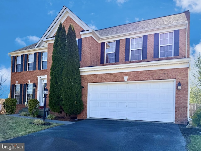 view of front of property featuring brick siding, an attached garage, and aphalt driveway