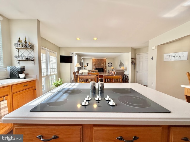 kitchen with a fireplace, light countertops, black electric stovetop, and french doors