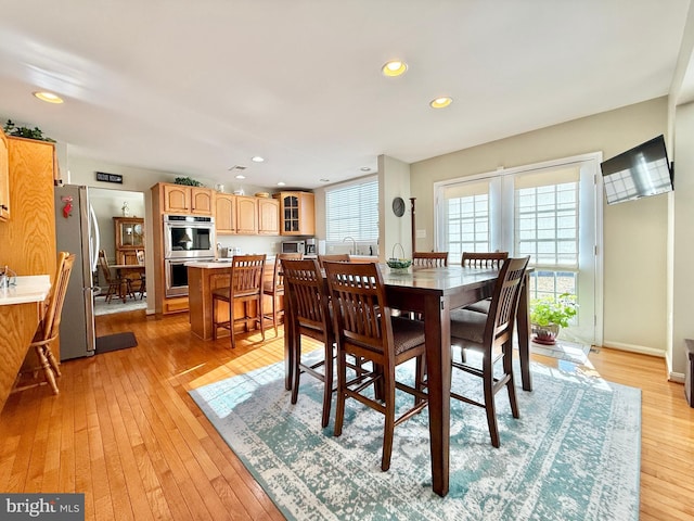 dining space with recessed lighting, light wood-type flooring, and baseboards