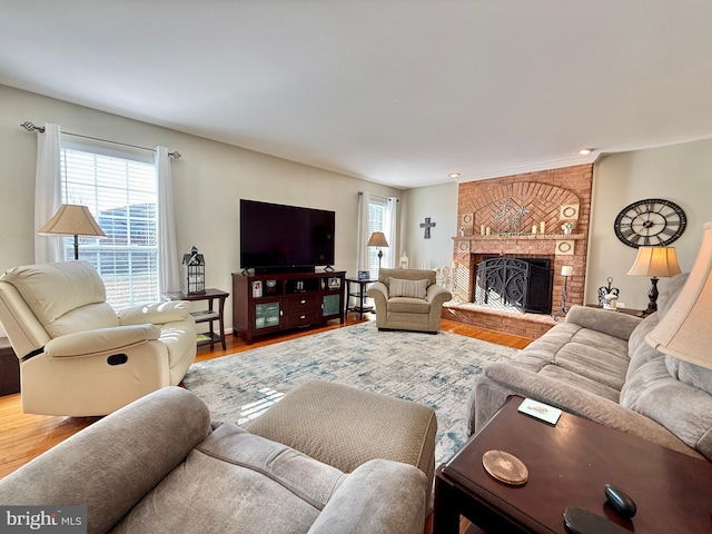 living room with plenty of natural light, wood finished floors, and a fireplace