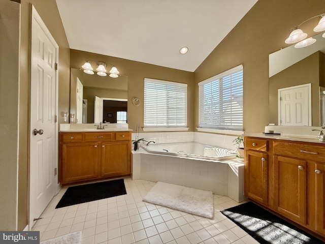 bathroom featuring two vanities, a sink, tile patterned flooring, vaulted ceiling, and a garden tub