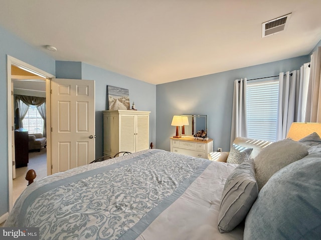 carpeted bedroom featuring visible vents