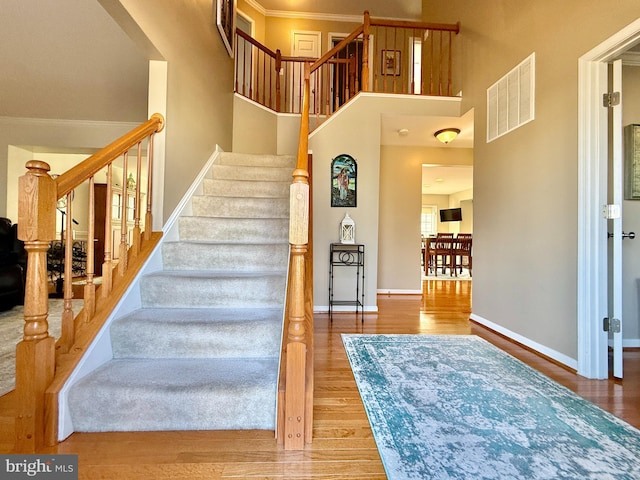 stairs featuring wood finished floors, visible vents, and baseboards