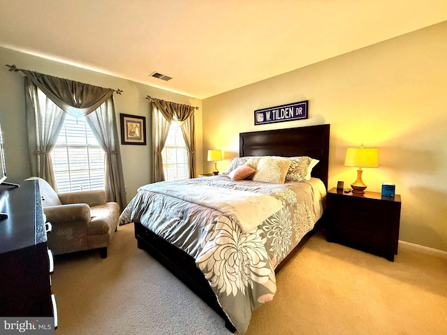 carpeted bedroom with baseboards and visible vents