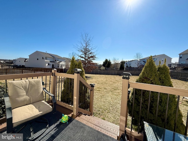 deck with a yard, a fenced backyard, and a residential view