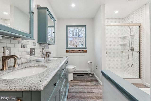 full bathroom with a sink, tasteful backsplash, a stall shower, and wood finished floors