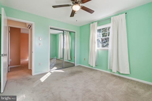 unfurnished bedroom with a ceiling fan, carpet, baseboards, attic access, and a closet