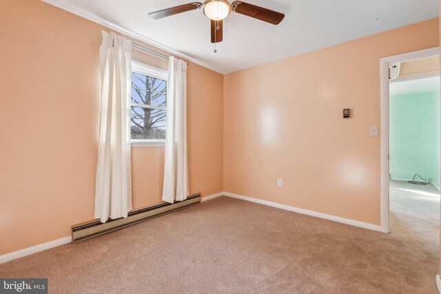 unfurnished room with a baseboard heating unit, baseboards, and carpet floors