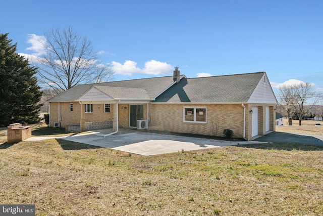 back of property featuring a patio, roof with shingles, a chimney, a lawn, and brick siding