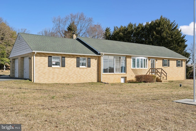 single story home with a front lawn, an attached garage, brick siding, and a chimney