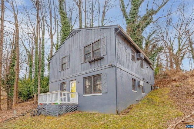 view of front of home with a wall unit AC and a deck