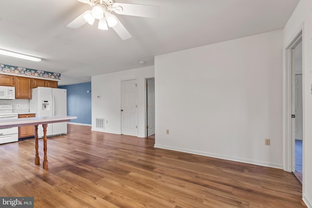 unfurnished living room featuring light wood finished floors, a ceiling fan, visible vents, and baseboards