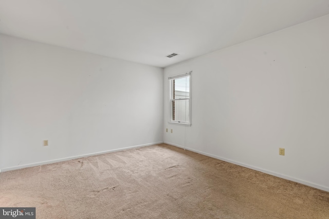 carpeted empty room with visible vents and baseboards