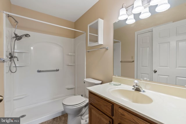 bathroom featuring vanity, walk in shower, toilet, and tile patterned floors