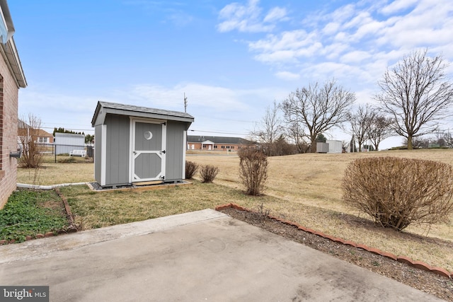 view of yard with an outbuilding, a patio, a storage unit, and fence